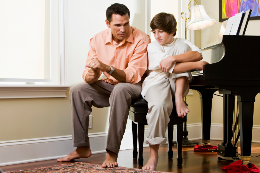 dad and son having a serious conversation near piano