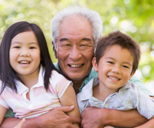 grandfather is hugging his grandchildren