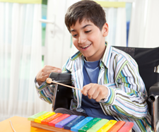 child with disability on a wheelchair is playing an instrument