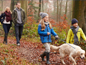 Family walking their dog through the woods